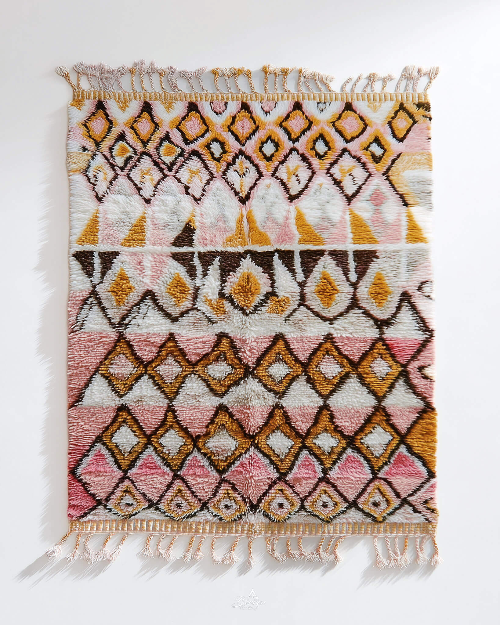 Decorative pink Moroccan rug with geometric pattern on a white background