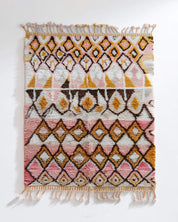 Decorative pink Moroccan rug with geometric pattern on a white background