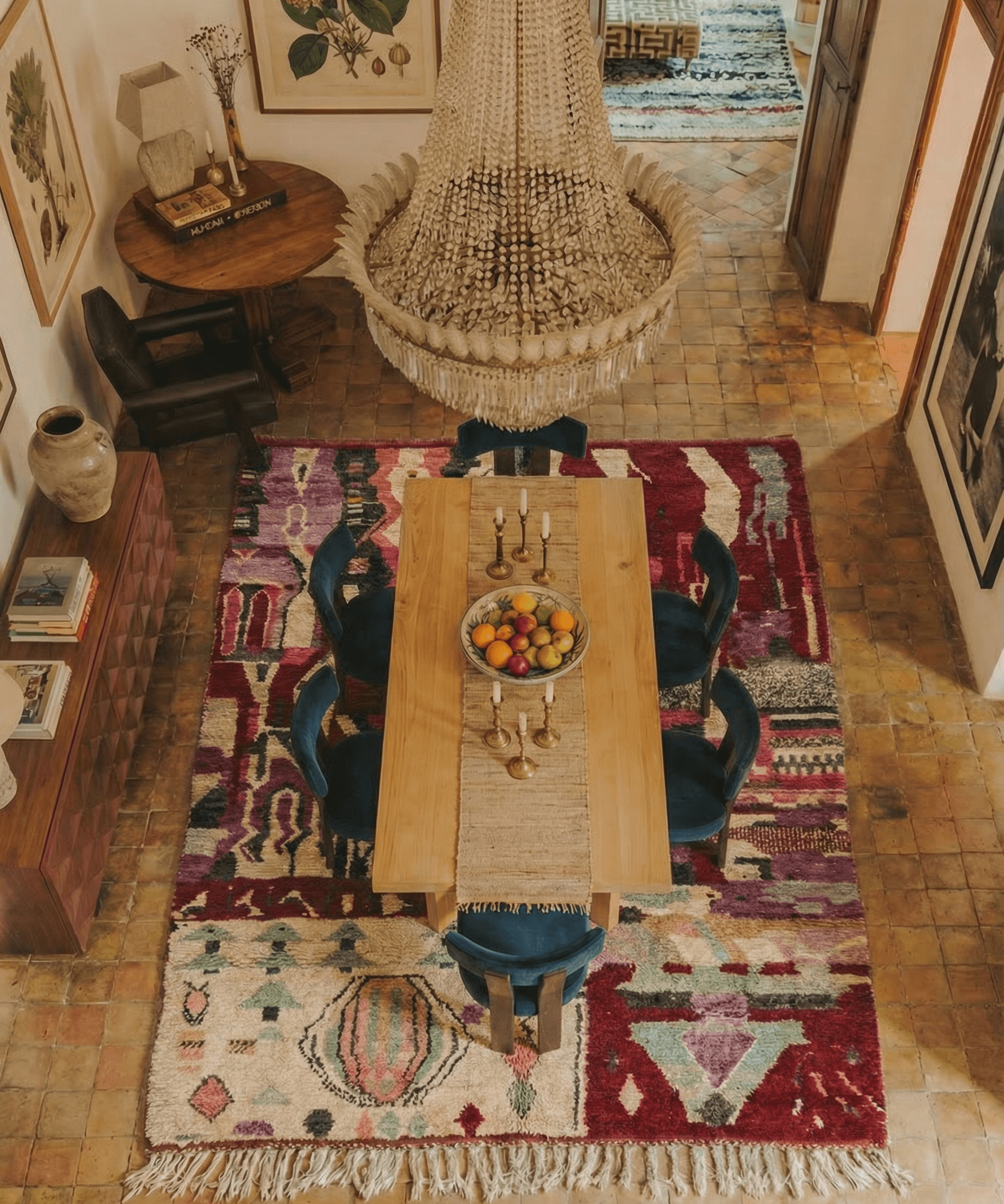 Dining room with a wooden table, chairs, and a colorful patterned rug.
