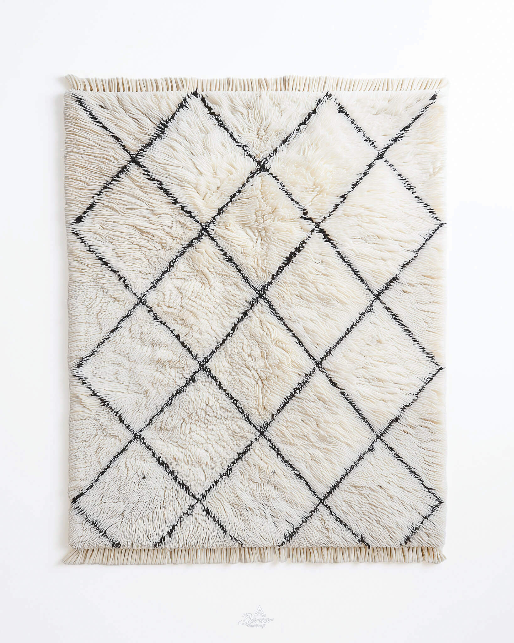 White Beni Ourain rug with black diamond pattern on a white background