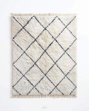 White Beni Ourain rug with black diamond pattern on a white background