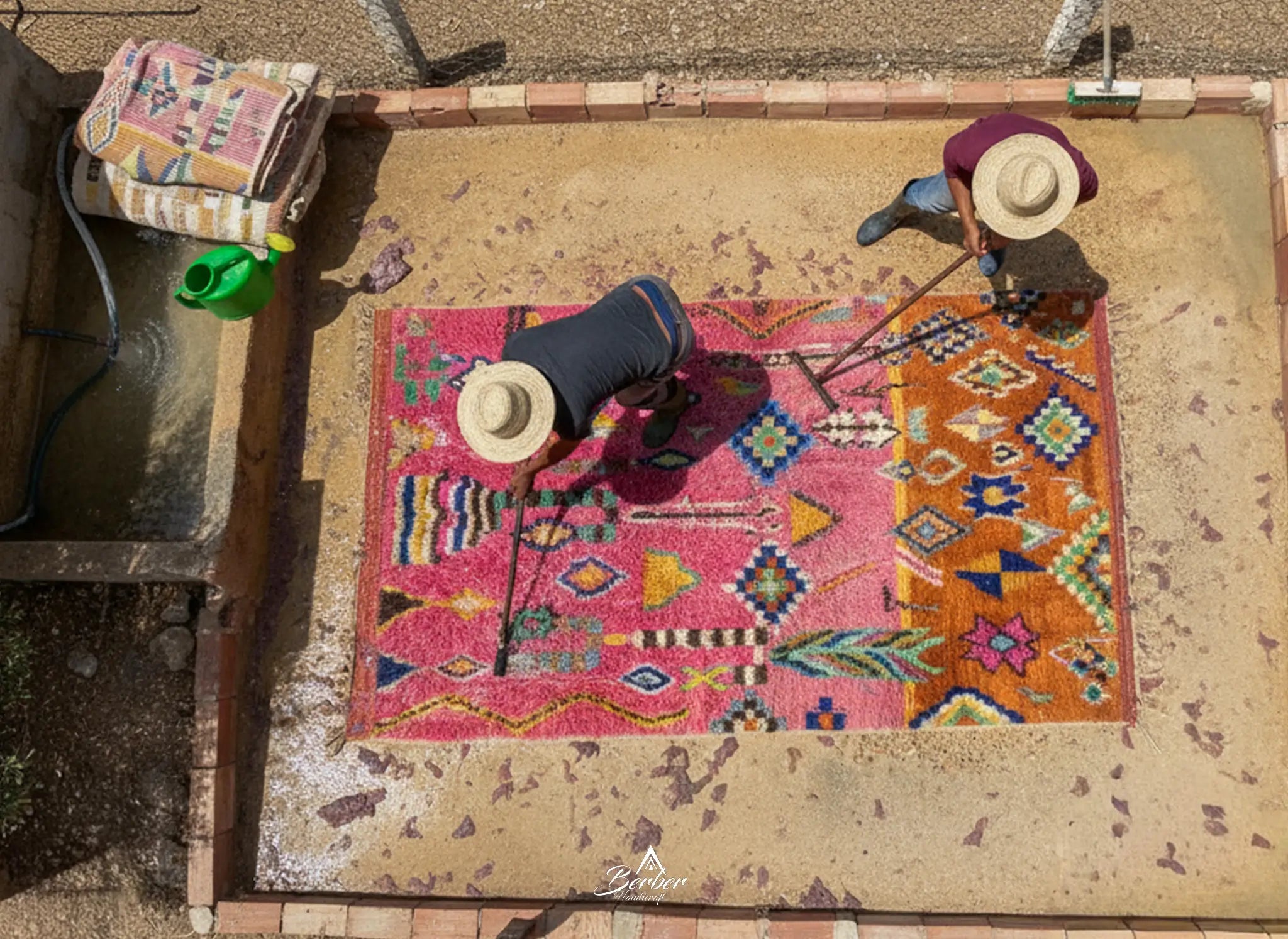 Two people washing a colorful moroccan rug